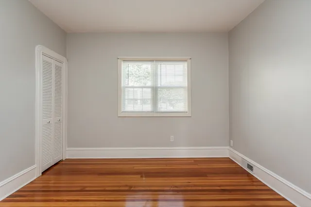 a view of a room with wooden floor and windows in it