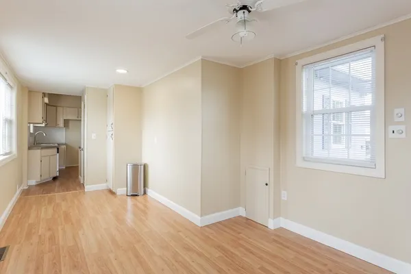 a view of a kitchen with wooden floor and a ceiling fan