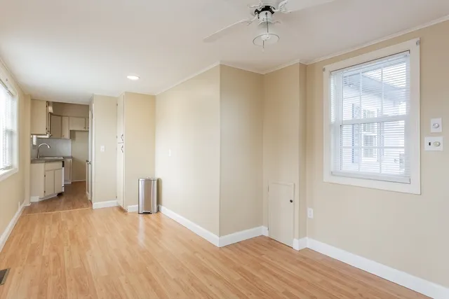a view of a kitchen with wooden floor and a ceiling fan