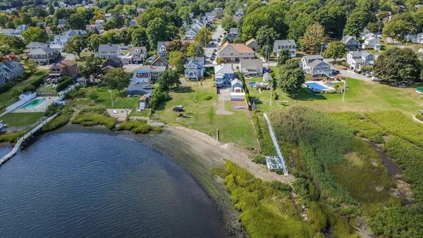 an aerial view of residential houses with outdoor space and trees