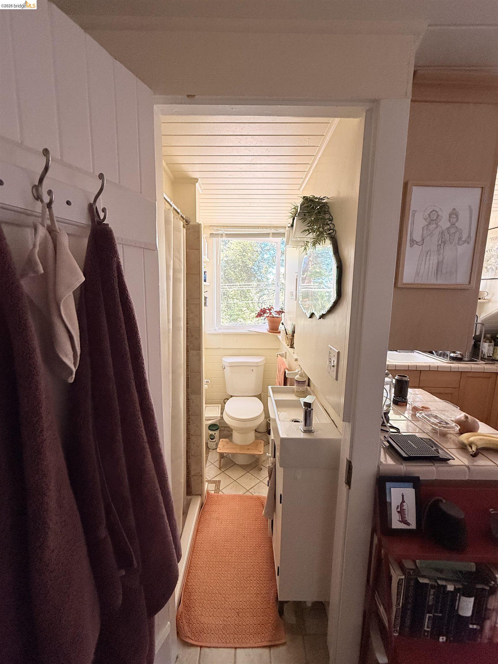 1631 La Vereda Road Berkeley, CA 94709 - Photo 32 of 42 Compact bathroom featuring a white vanity with an integrated sink, a commode, and a window providing natural light