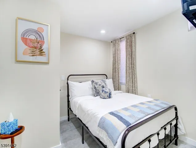 a bedroom with a bed and a painting on the wall