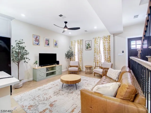 a living room with furniture a flat screen tv and a large window