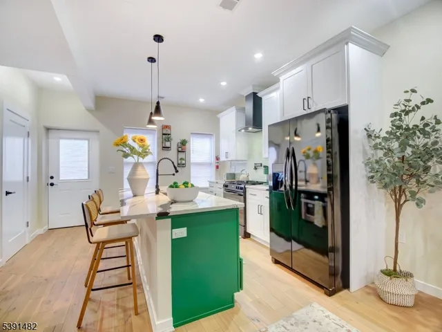 a kitchen with stainless steel appliances kitchen island granite countertop dining table chairs and a window