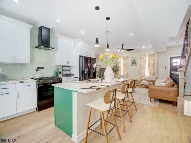 a kitchen with a table chairs stove and wooden floor
