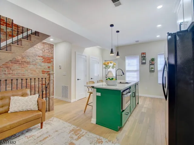 a kitchen with stainless steel appliances kitchen island granite countertop a refrigerator and a sink