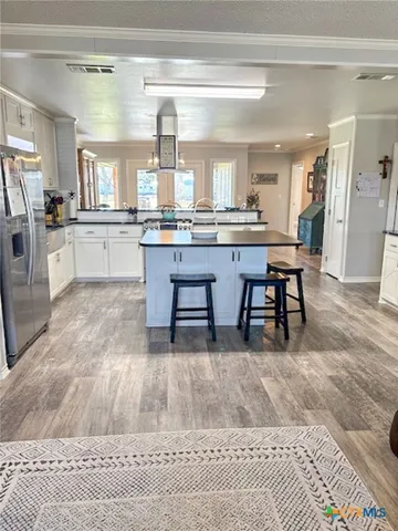 a living room with a couch and a dining table with wooden floor