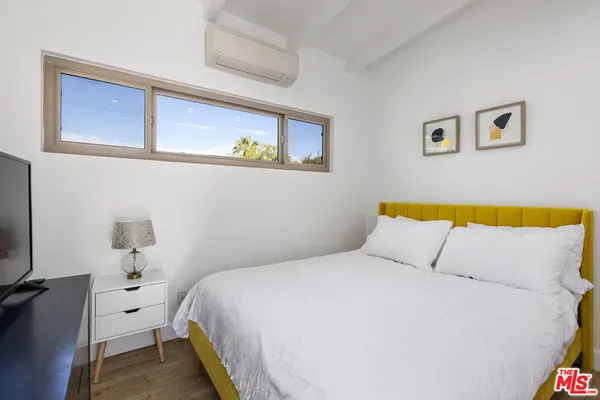 a bedroom with a bed and a flat screen tv