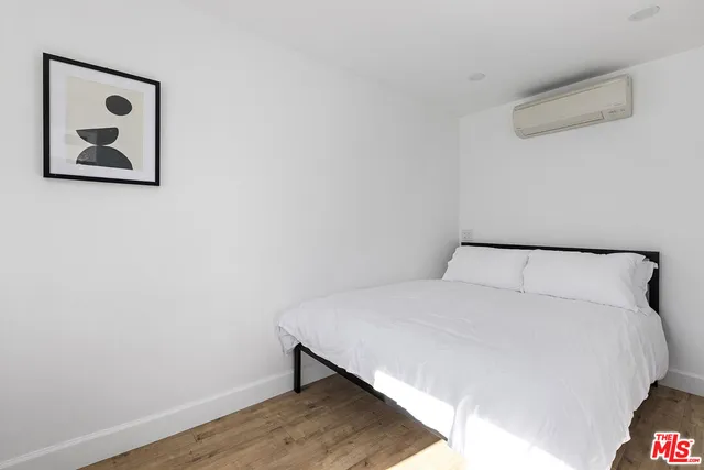 a bedroom with a bed and a painting on the wall