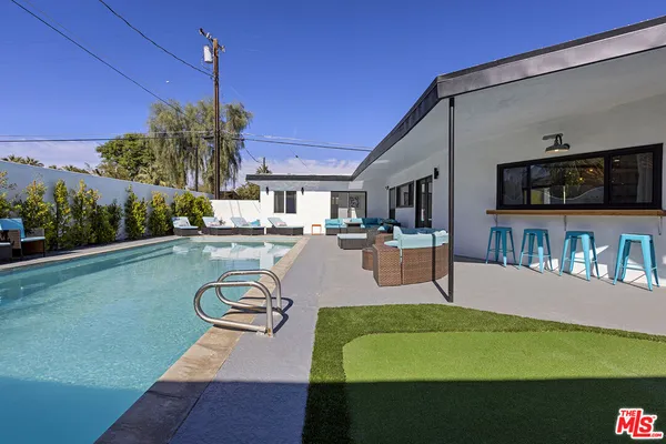 a swimming pool view with a seating space