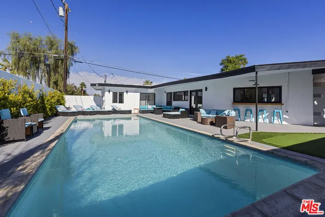 a swimming pool view with a outdoor seating
