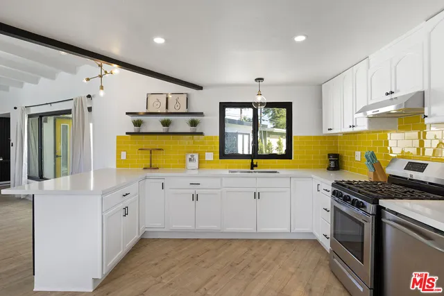 a kitchen with stainless steel appliances granite countertop a stove a sink and a refrigerator