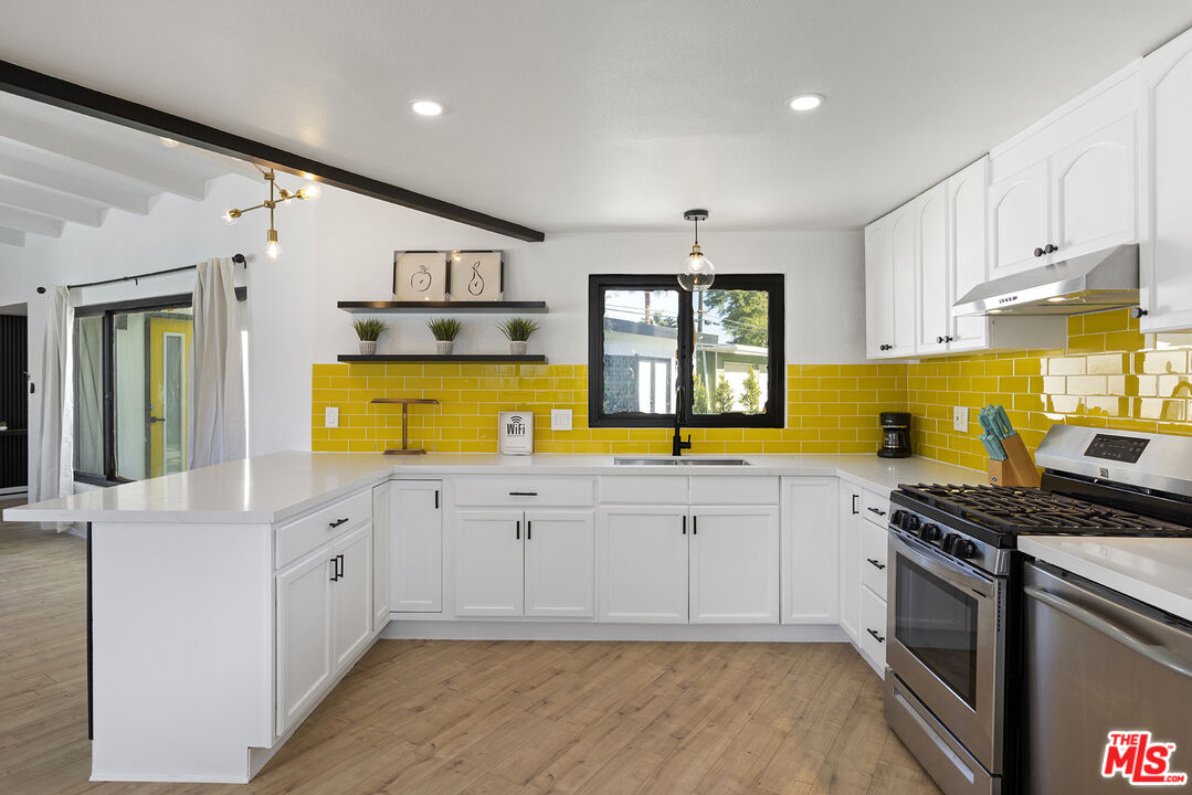Undisclosed Address Palm Desert, CA 92260 - Photo 9 of 24 a kitchen with stainless steel appliances granite countertop a stove a sink and a refrigerator
