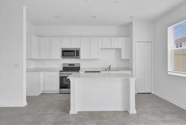 a kitchen with cabinets stainless steel appliances and a window