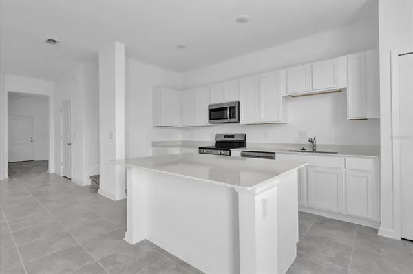 a kitchen with cabinets appliances a sink and a counter top space