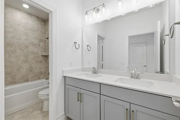 a bathroom with a granite countertop sink a toilet and a bathtub