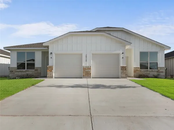 a view of a house with a yard and garage