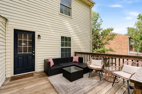 a balcony with wooden floor and furniture