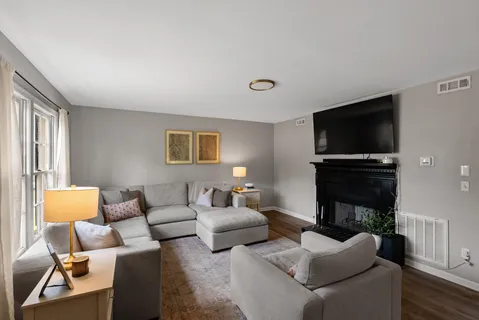 a living room with furniture a flat screen tv and a fireplace