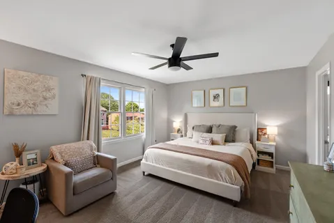 a bedroom with a bed couches and window