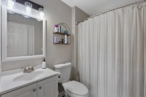 a bathroom with a sink vanity mirror and toilet