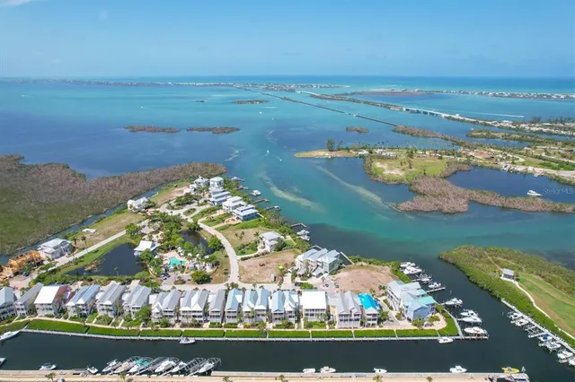 an aerial view of ocean and residential houses with outdoor space