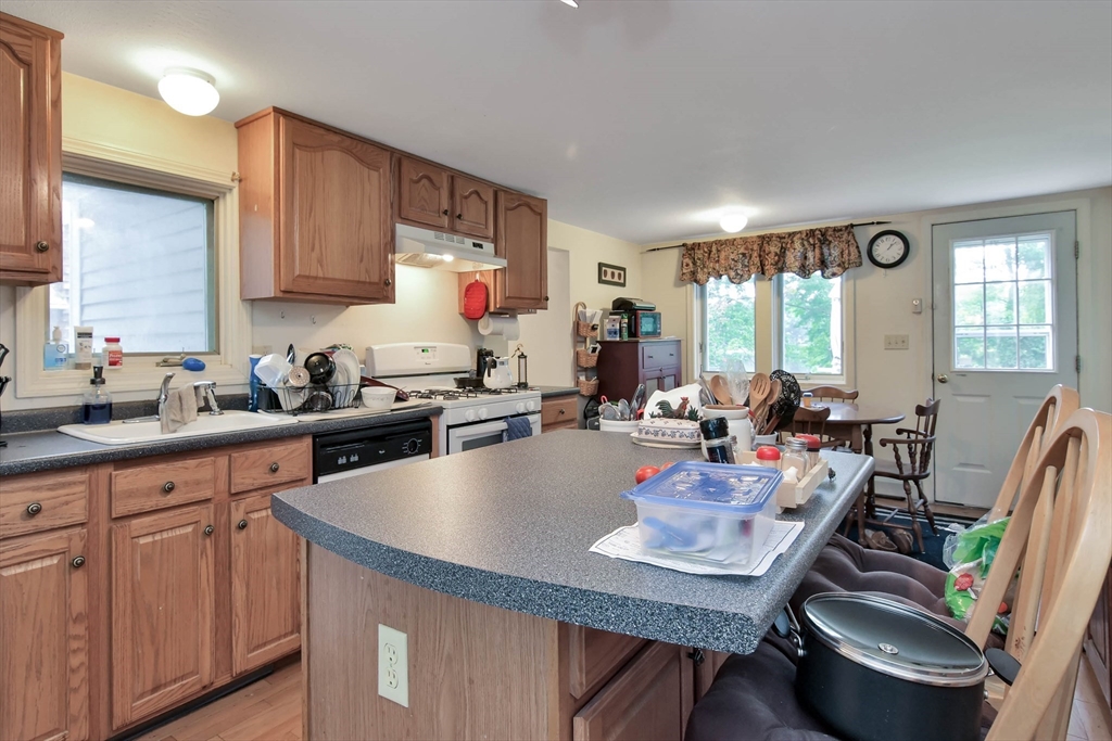 438 Boston Post Road Amherst, NH 03031 - Photo 18 of 32 a kitchen with a table chairs stove and kitchen island