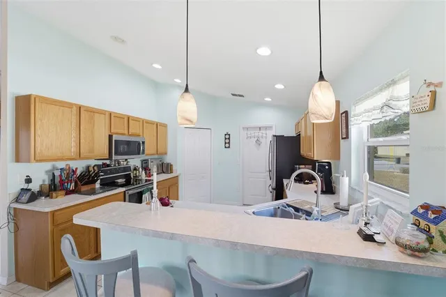 a kitchen with a dining table chairs sink and microwave