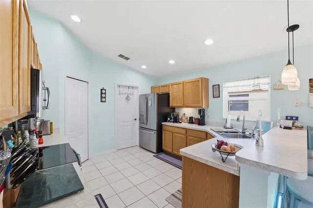 a kitchen with sink refrigerator and stove top oven