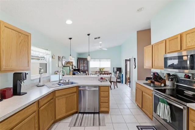 a kitchen with stainless steel appliances kitchen island granite countertop a stove a sink a refrigerator and blue cabinets