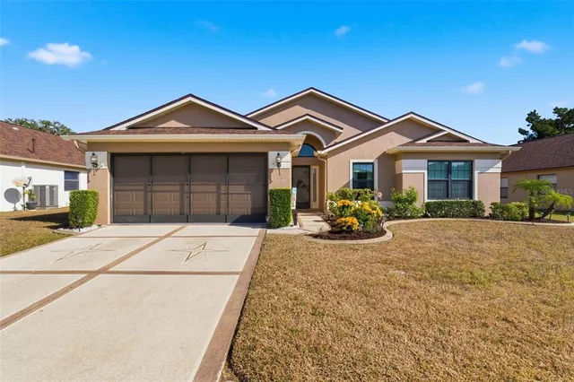a view of a house with a small yard and potted plants