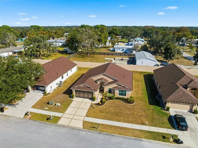 an aerial view of residential houses with outdoor space and ocean view