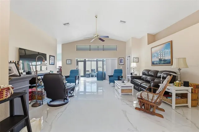 a living room with furniture a flat screen tv and a table