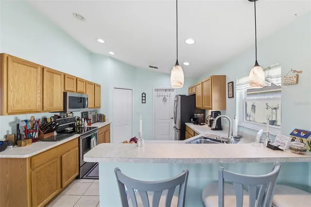 a kitchen with a stove a sink a kitchen island with a dining table and chairs