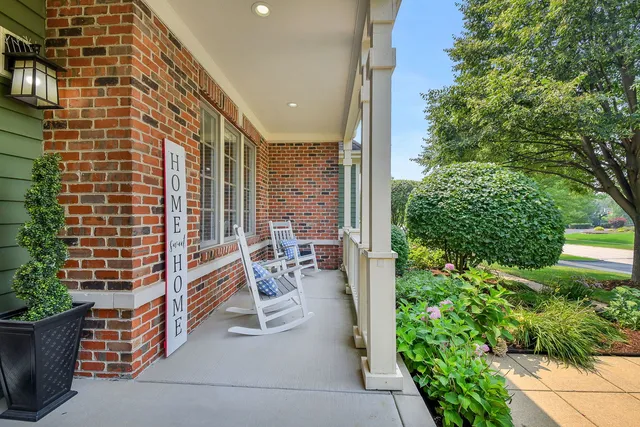 a balcony with chairs and with potted plants