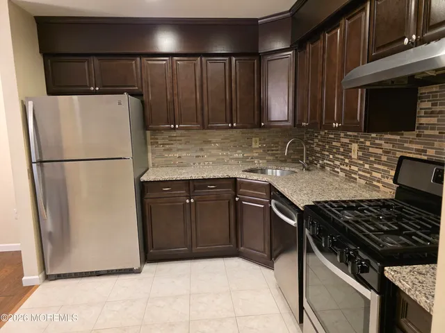 a kitchen with wooden cabinets and a stove top oven