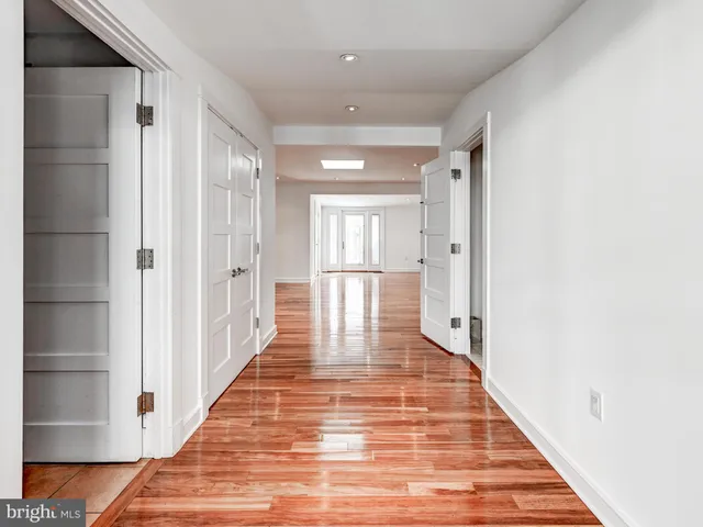 a view of a hallway with wooden floor and staircase