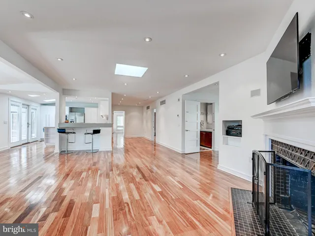a view of empty room with wooden floor and fireplace
