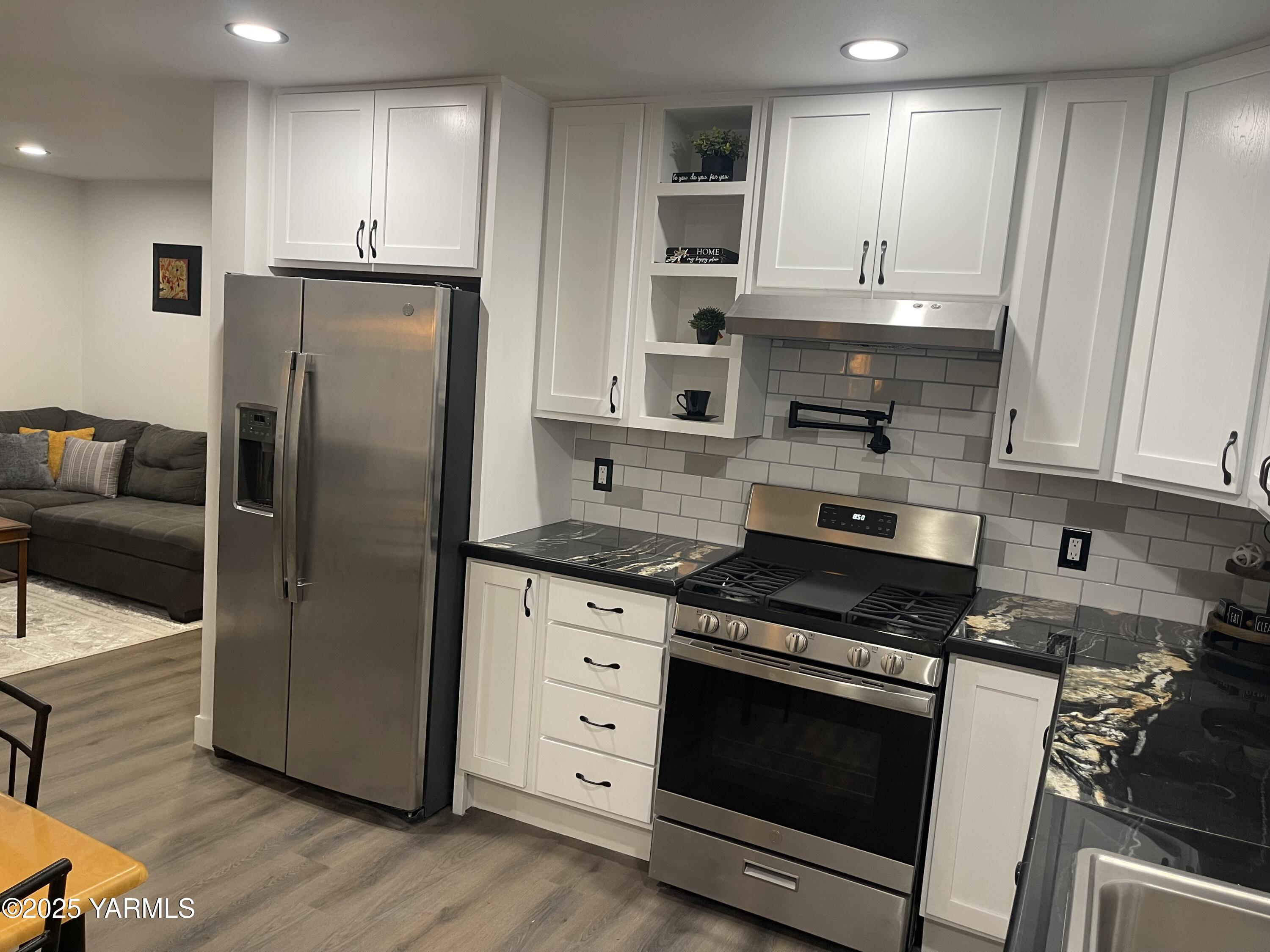 212 West Boulevard, Unit S Granger, WA 98932 - Photo 12 of 40 a kitchen with stainless steel appliances granite countertop a stove a refrigerator and a microwave