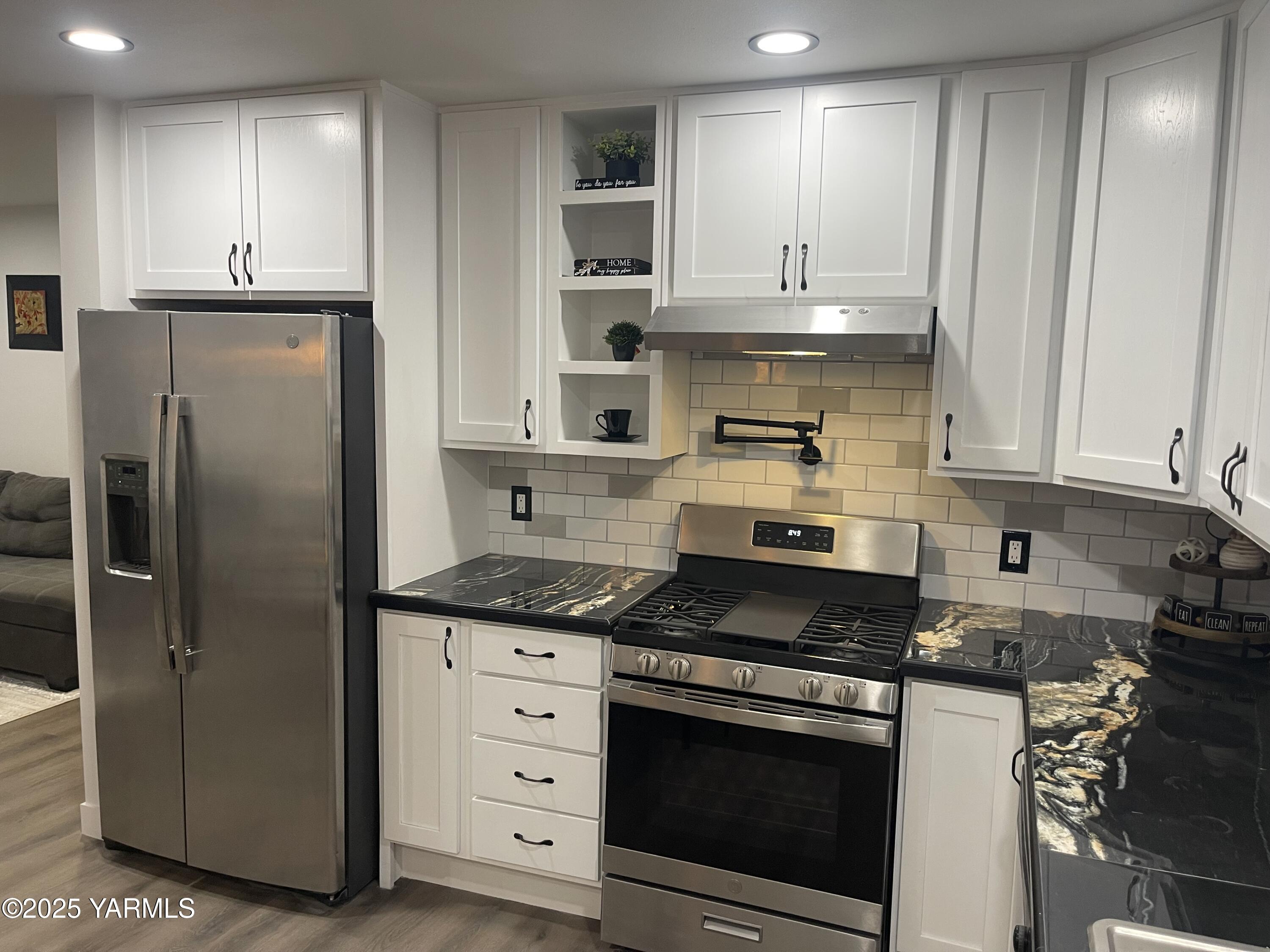 212 West Boulevard, Unit S Granger, WA 98932 - Photo 15 of 40 a kitchen with stainless steel appliances granite countertop a stove a refrigerator and a microwave