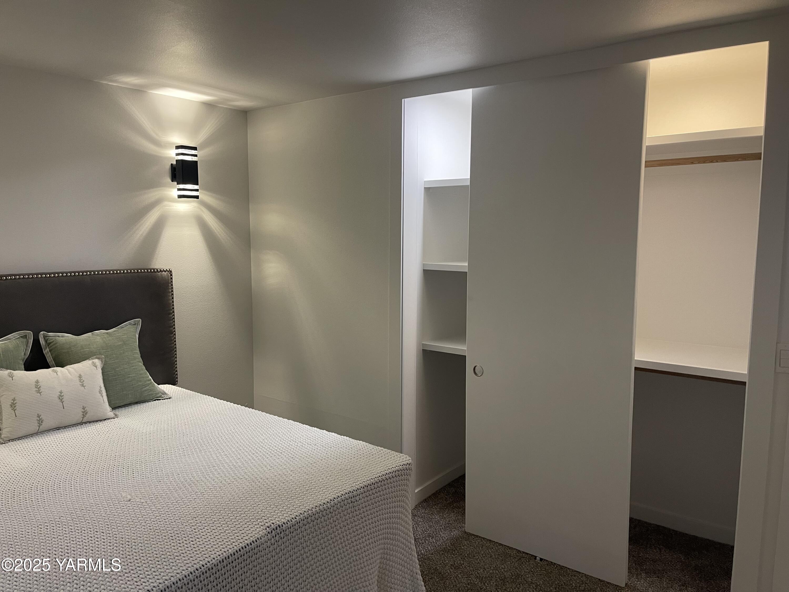 212 West Boulevard, Unit S Granger, WA 98932 - Photo 37 of 40 a bedroom with a bed and a walk in closet