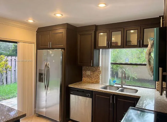 a kitchen with granite countertop a stove a sink and a microwave
