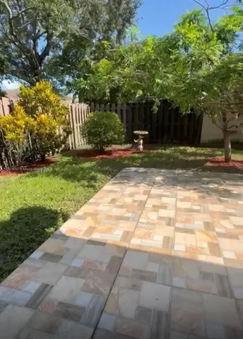 a backyard of a house with lots of green space and wooden fence
