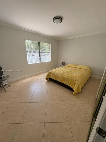 a bed sitting in a bedroom next to a window