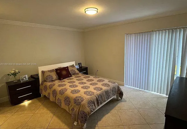 a bedroom with a bed and a lamp on the dresser
