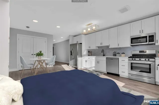 a kitchen with stainless steel appliances kitchen island granite countertop a stove a sink and a refrigerator