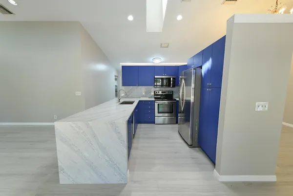 a kitchen with stainless steel appliances granite countertop a refrigerator and a stove