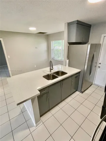 a kitchen with a sink a refrigerator and washer