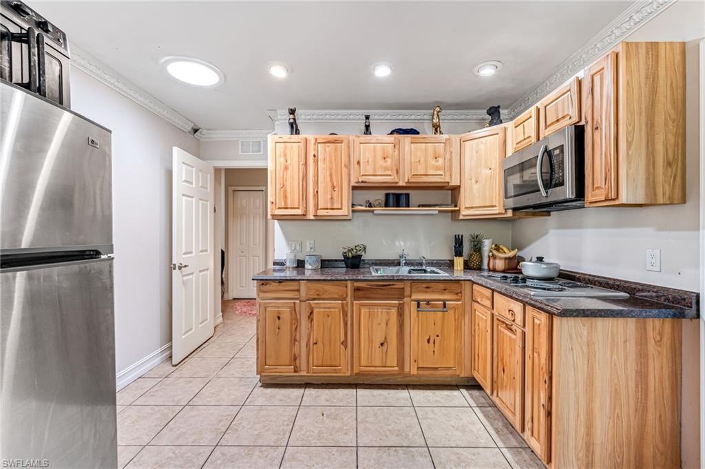 724 Pine Cone Lane Naples, FL 34104 - Photo 16 of 45 a kitchen with stainless steel appliances granite countertop a refrigerator sink and cabinets