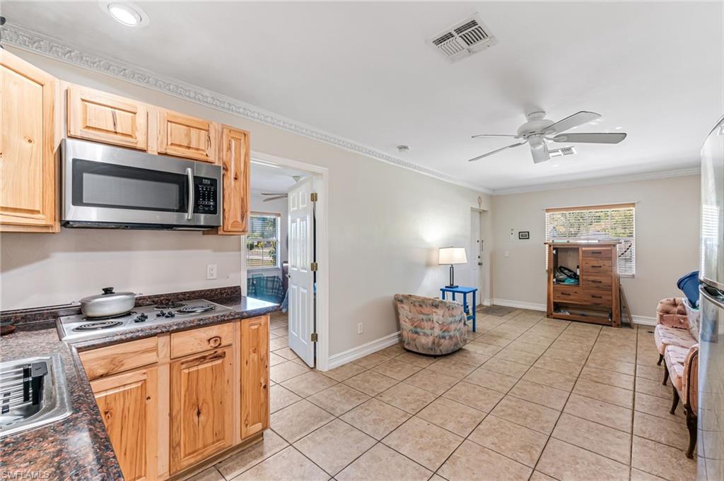 724 Pine Cone Lane Naples, FL 34104 - Photo 17 of 45 a kitchen with stainless steel appliances kitchen island granite countertop a sink cabinets and microwave